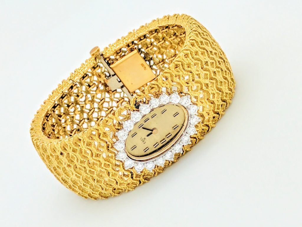 Single gold watch with diamonds around the time piece